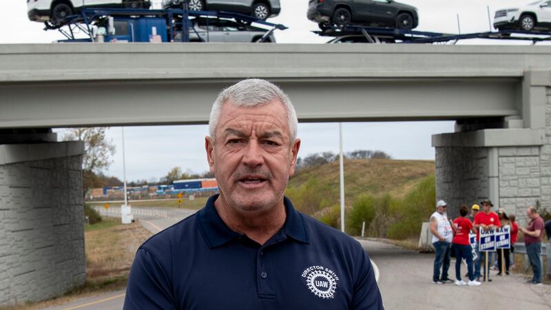 Tim Smith, UAW Region 8 director, stands outside with other workers while picketing near the...
