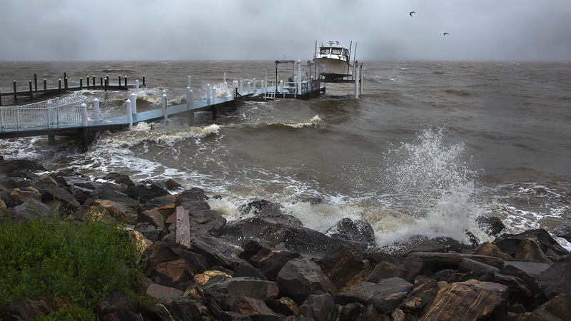 Waves generated by Tropical Storm Ophelia crash up on the banks of the Potomac River along...