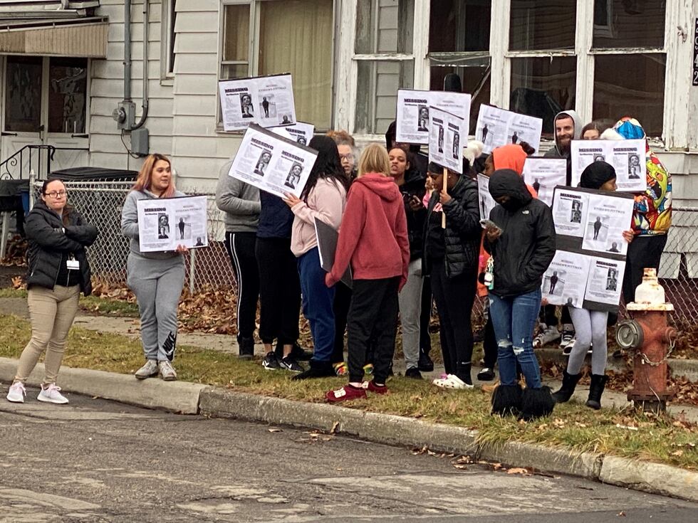 A crowd holding missing person posters is gathering near the scene on Chase Street where...