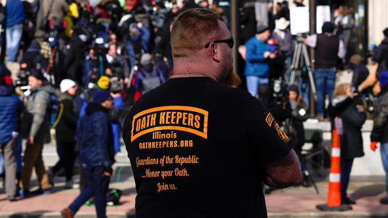 FILE - A man wearing an Oath Keepers shirt stands outside the Kenosha County Courthouse, Nov....