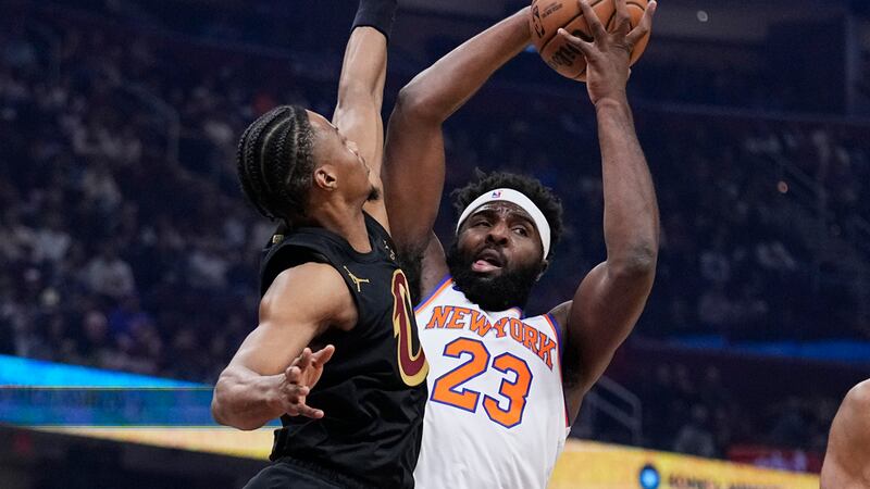 New York Knicks center Mitchell Robinson (23) grabs a rebound next to Cleveland Cavaliers...